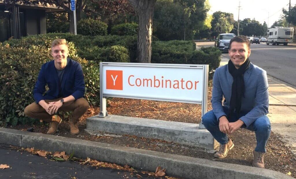 Os proprietários da Veriff se agachando ao lado de uma placa que diz Y Combinator