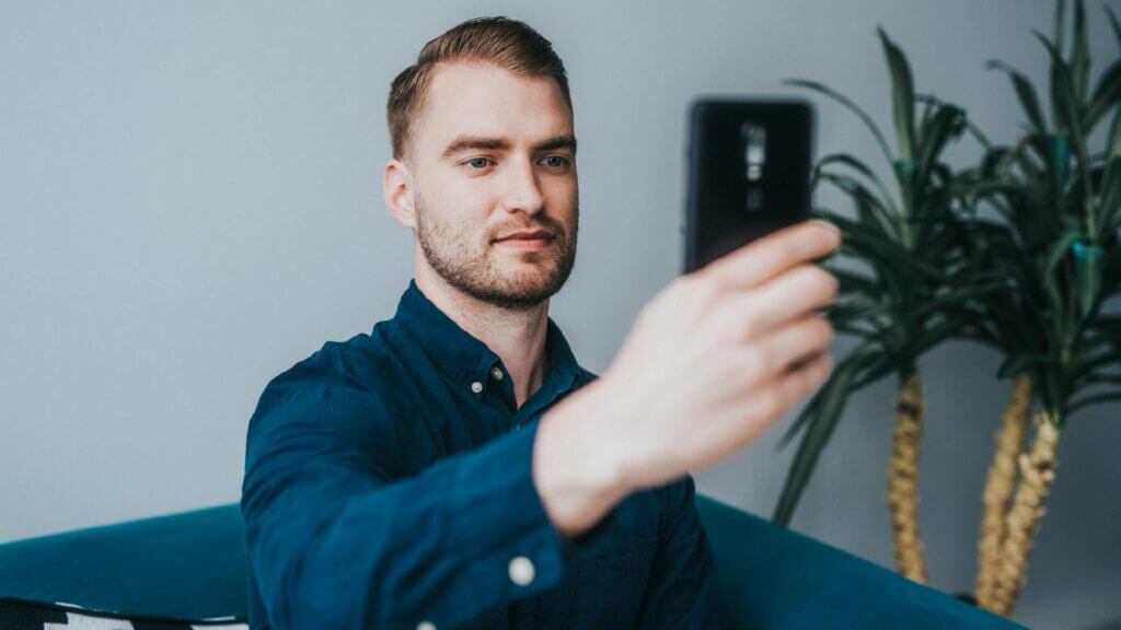 A well groomed man, taking a selfie for verification purposes.