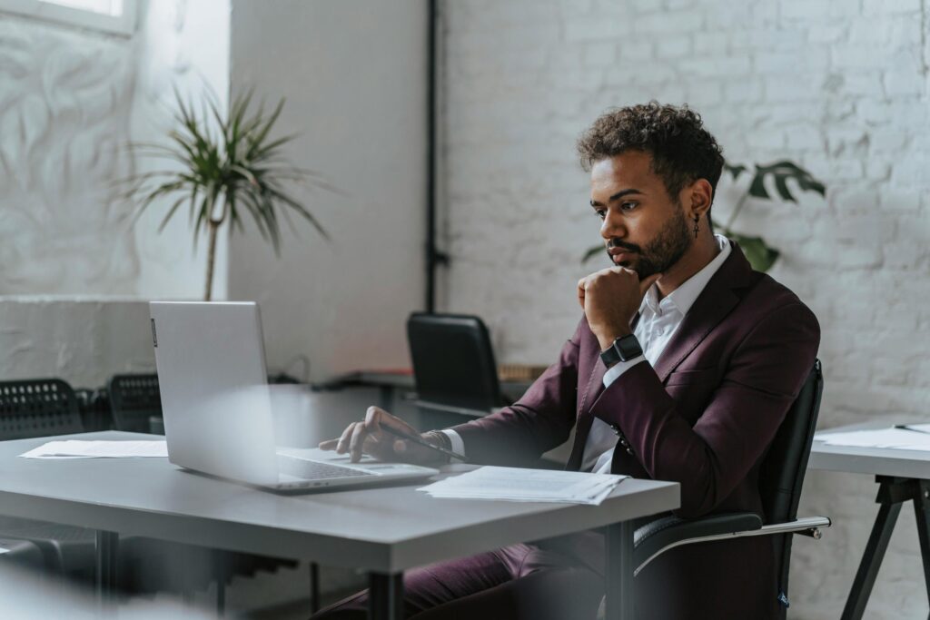 a man sitting at a desk with a laptop