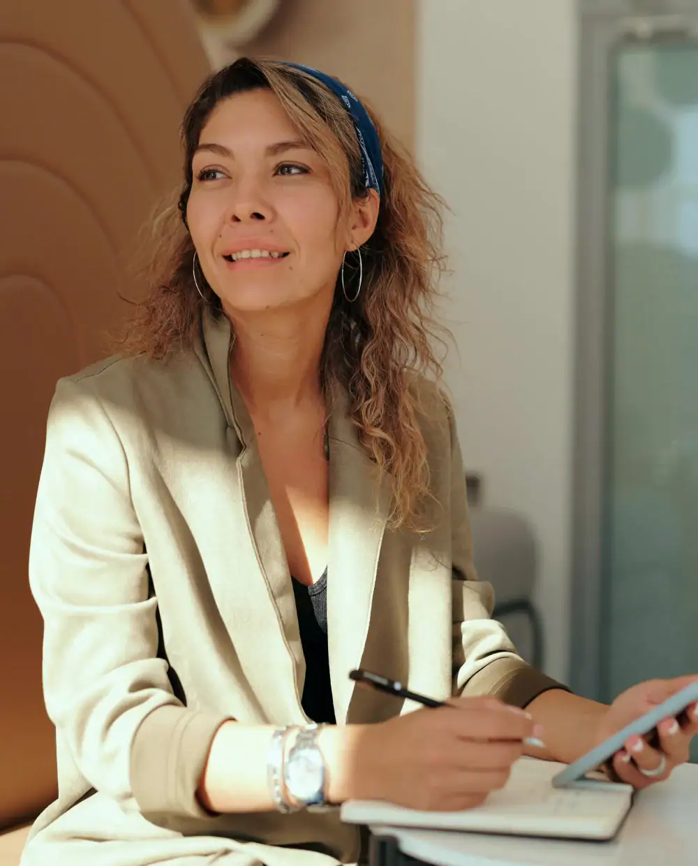 A woman on using her phone and writing down
