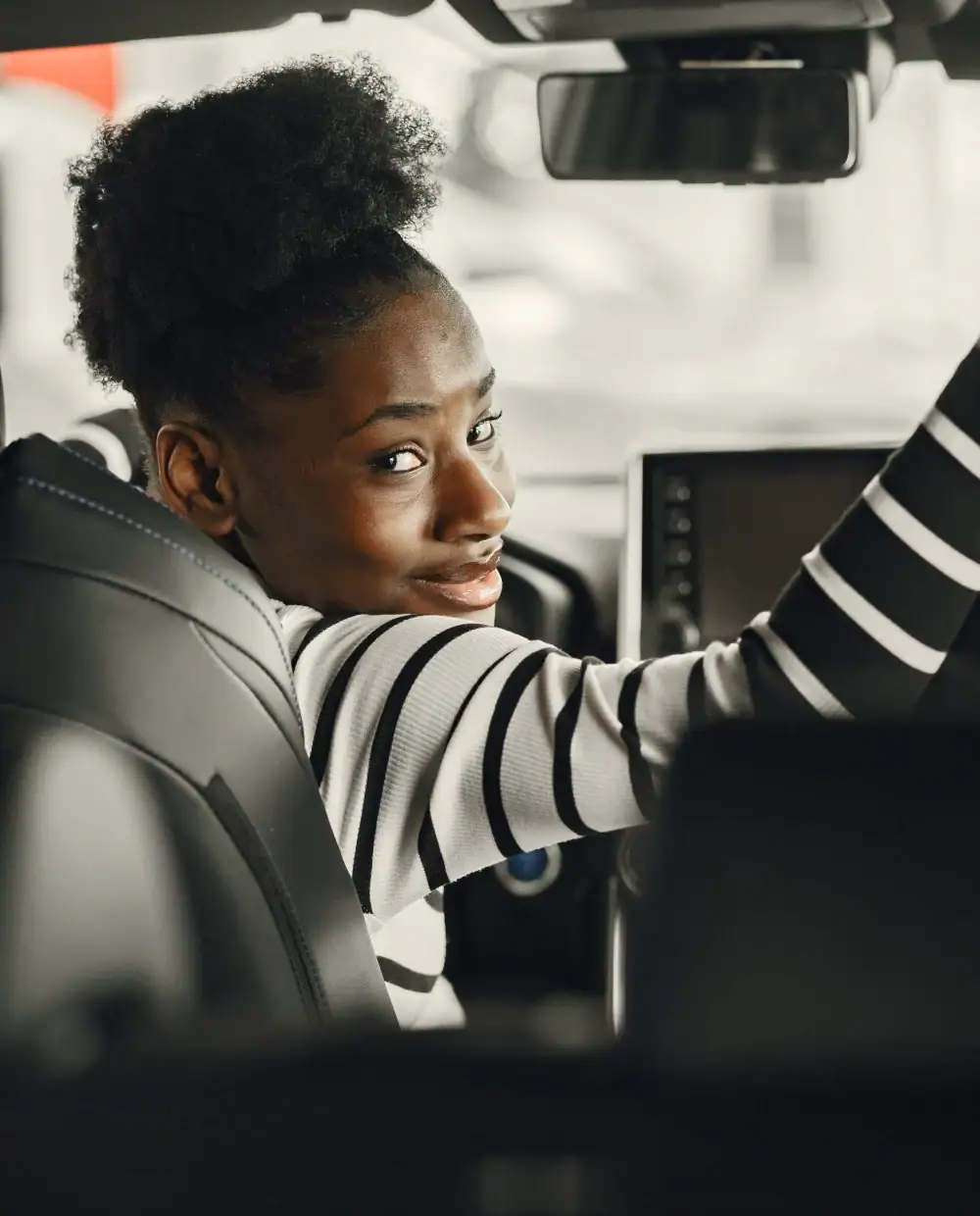 A delivery driver smiling in the front seat of a vehicle